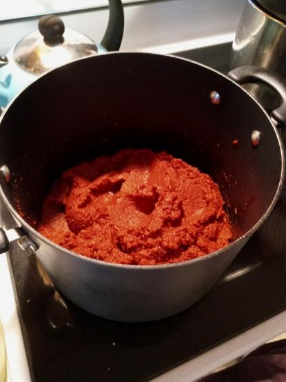 Photo of a pot of what looks like, but is not, tomato paste on the stove