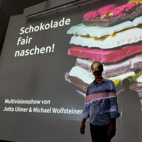 Michael vor dem Titelbild der Show "Schokolade fair naschen!"