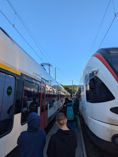 Le quai entre voie 1 et 2 en gare du Pont dans la vallée de Joux. Il ne fait que 1m de large et on ne peut y accéder qu'une fois les deux trains entrés en gare. Les voyageurs semblent être un peu à l'étroit entre les deux trains.