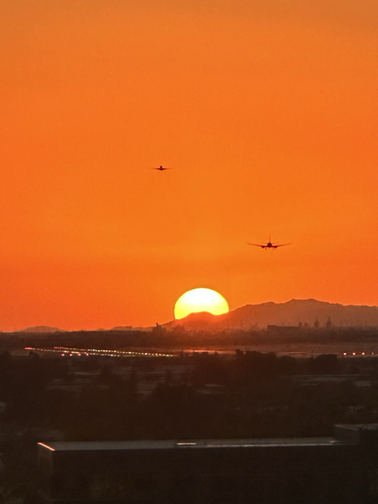 Planes taking off into the sunset with mountains 
