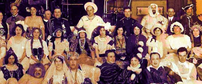 Une photo de groupe de personnes déguisées pour un carnaval. Tout le monde regarde l'objectif.