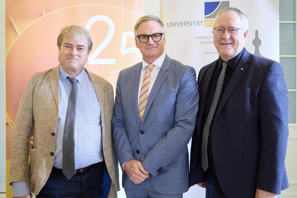 Rektor Prof. Michael Hoch und Prof. Jürgen Hammerstaedt gratulieren Prof. Dirk Lanzerath zum 25. Jubiläum des DRZE. (c) Volker Lannert