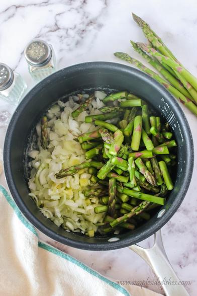 Asparagus, onions, leeks and butter in a pot, uncooked