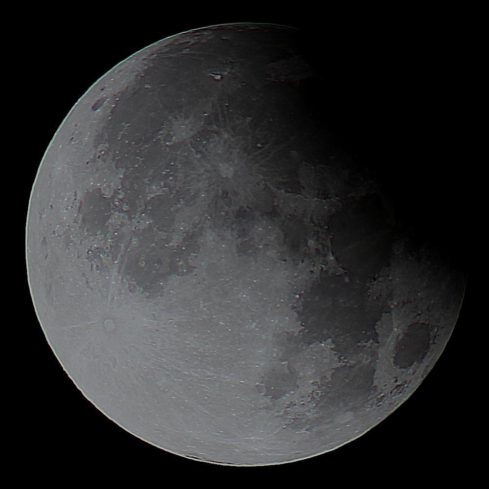 The Moon partially covered by Earth's shadow at upper right on a dark background. 