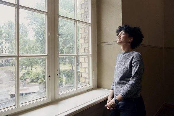 Yasmine Boudiaf looking through a window. Photo: Maria Silvano. Taken at the Disruption Network Lab conference #ARTIVISM: The Art of Subverting Power: https://dnlb.org/ar