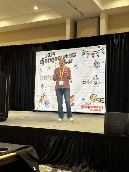 Natalia Bidart giving a DjangoCon US keynote on stage telling us about the role of being a Django Fellow.