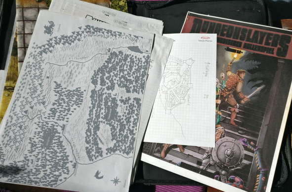 Karte einer Fantasy-Welt und ein selbst ausgedrucktes Regelbuch von Dungeonslayers.