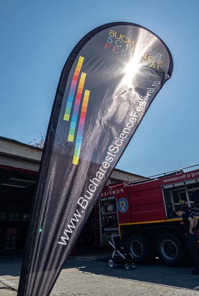 A banner for the Bucharest Science Festival seen against a blue sky with the Sun shining through.