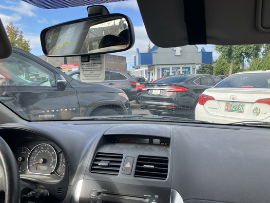 About four layer of cars are between us (stuck in the road) and the Dutch Bros coffee kiosk