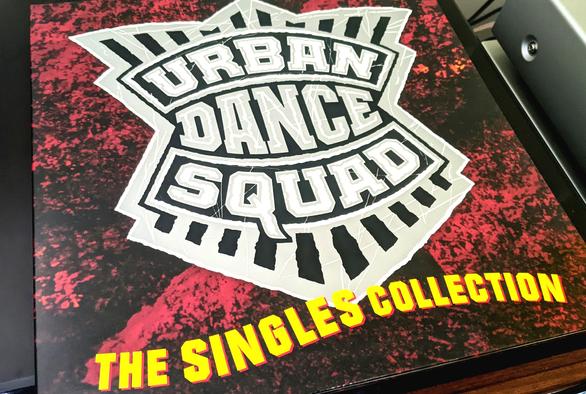 Cover of the Urban Dance Squad Singles Collection album. Album is lying on cover of the turntable.