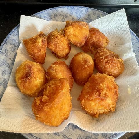 A plate of freshly made golden-brown roast potatoes, arranged on a paper towel, showing a crispy exterior and a soft interior.