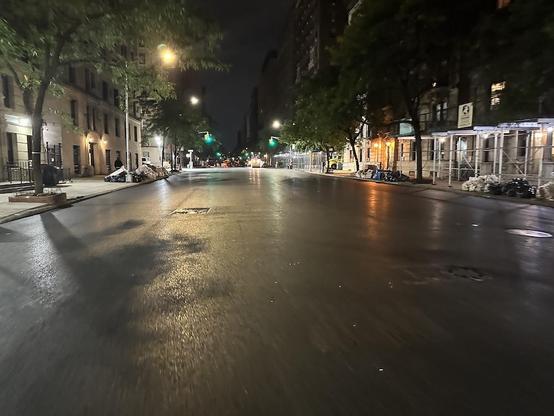 Night-time photo of a black, shiny, empty NY avenue. Absolutely no cars, not even parked, for the next two blocks. NYC DOT has just finished resurfacing, and my skate wheels may be the first civilian wheels to  roll this way.