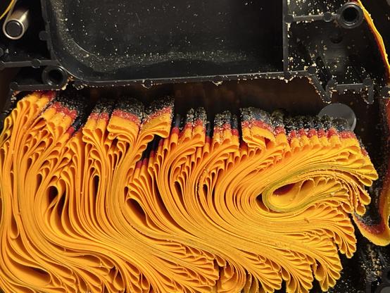 Inside a color ImageWriter II ribbon which has lots of yellow foam flecks stuck to it still. 