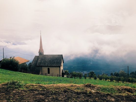 A tiny church on the mountains and fog in the valley