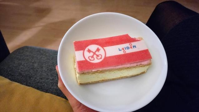 Tompouce with the flag and logo of the city of Leiden in red and white on it, in a white bowl