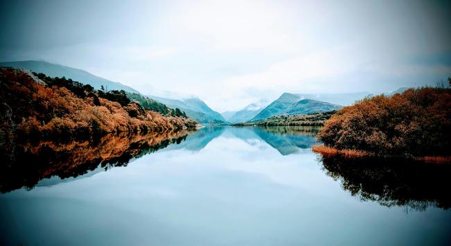 Photo of a Welsh lake with mountains in the background on a cloudy autumn day