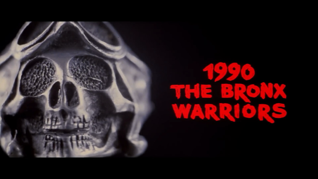The title screen of the movie 1990: The Bronx Warriors. A metal skull is on the left, the movie title is shown in red letters along the right side of the image.