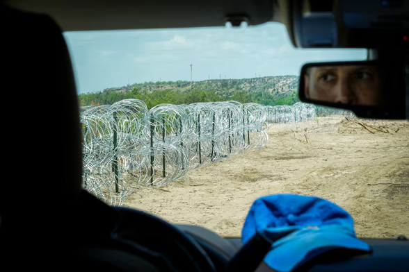 Poncho Nevárez drives along a stretch of razor wire on his property along the Rio Grande on Aug. 19, 2022, in Eagle Pass. As part of Operation Lone Star, Nevárez agreed to have the National Guard install two miles of the fencing along his ranch’s riverfront.(Smiley N. Pool / Staff Photographer)