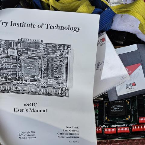 A devry university eSOC board with user manual. It is from the year 2000. A Zip fisk is displayed out of the case on yhe board.