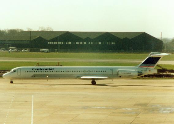 A mainly white with blue and red detailing airliner taxying from right to left.