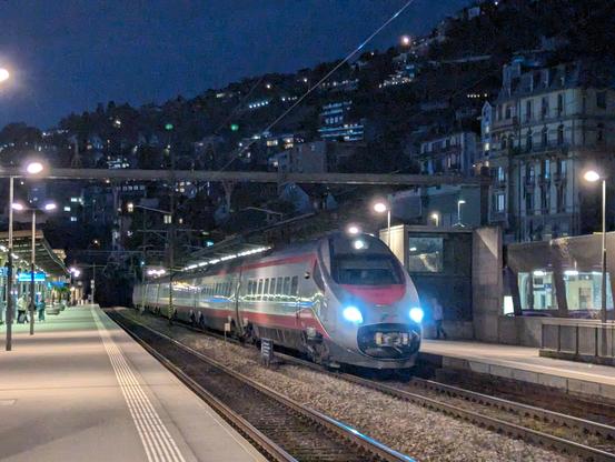 EuroCity 41 Genève Milan en gare de Montreux. Pris en toute sa longueur depuis le quai d'en face. Ses éclaireurs bleus se démarquent des trains suisses. En arrière fond les hauts de Montreux.
