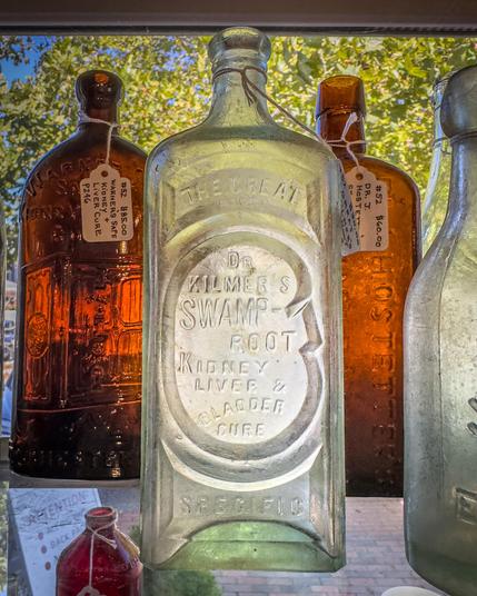 A photograph of an empty antique bottle of Dr. Kilmer's Swamp Root Kidney, Liver, and Bladder Cure.

