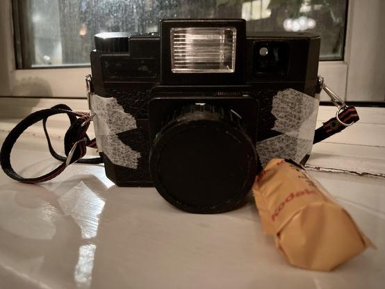 Holga camera with white sports tape on the sides.