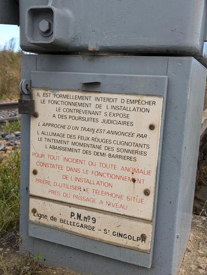 Plaque indiquant des directives sur le comportement à adopter en cas de soucis sur le passage à niveau. En dessous il est écrit : PN9 - ligne de Bellegarde à St Gingolph.