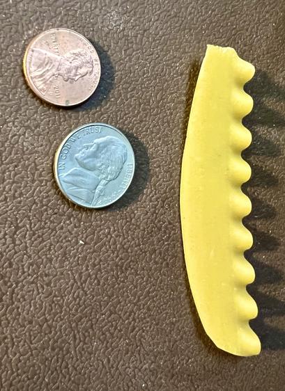A broken piece of the scalloped edge of a uncooked lasagna noodle on a brown background. A US Penny (1 cent) and Nickle (five cents) is shown for scale.

Stupid pasta.