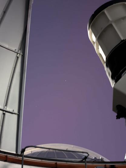 Looking out the open dome of the Allan I Carswell Observatory 60cm telescope we see the 1m dome and Aurora in the sky. The 60 itself is pointed out alongside the right of the image 