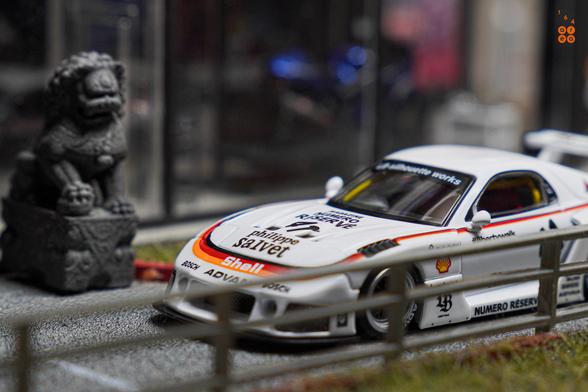 A focus shot on front side of Mazda RX-7 FD3S, LB-Super Silhouette, Numero Réservé livery by iNNO64 in 1:64 scale on AREA 164