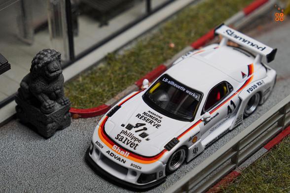 A focus shot on top view of Mazda RX-7 FD3S, LB-Super Silhouette, Numero Réservé livery by iNNO64 in 1:64 scale on AREA 164