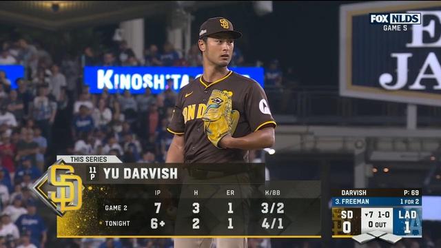 Image of Yu Darvish, a pitcher for the San Diego Padres, on the mound during a baseball game. The scoreboard displays game statistics and highlights, including innings pitched and earned runs. Fans are visible in the background, creating a lively atmosphere.