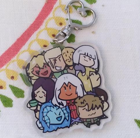 Photo of an acrylic charm with several cartoonist characters from Xenoblade X. Elma (white hair, brown skin, I love her) in the center, surrounded by other playable characters.