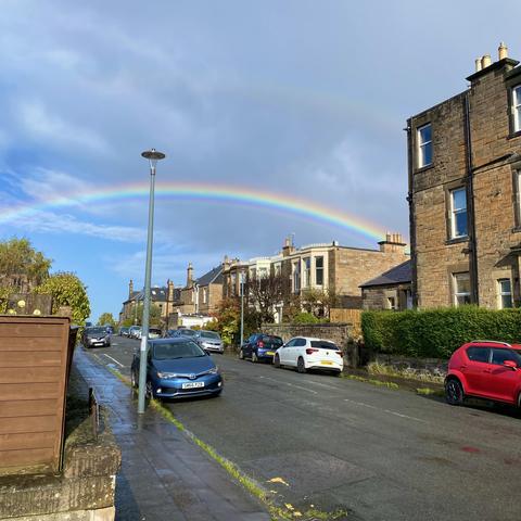 Bright rainbow, faint double, clouds clearing way for blue sky