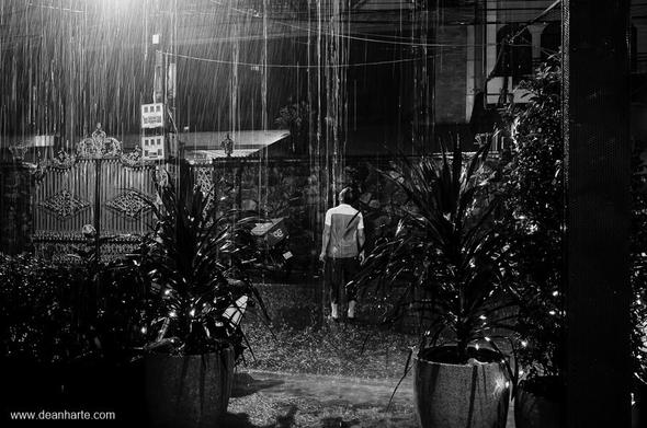 A man walks out into the street to welcome the first majour downpour of the rainy season