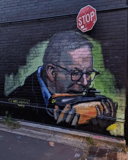 Van Thanh Rudd, ‘Hungry for War’, 2023.

Mural art illustrating Prime Minion Ant Albanese eating AUKUS nuclear submarine - a “sub” a submarine in a “subway” sandwich 
With a STOP sign above.