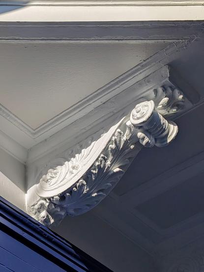 Ornate architectural bracket with scroll and leaf flourishes.