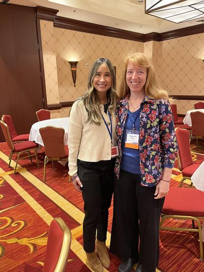 2 people standing next to each other in a conference room