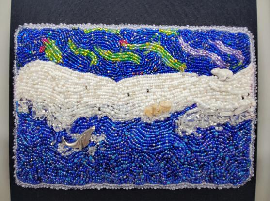 Bead embroidered scene of a polar bear 🐻‍❄️ on a snowy rise and a humpback whale 🐋 in the ocean watching the Northern Lights.
