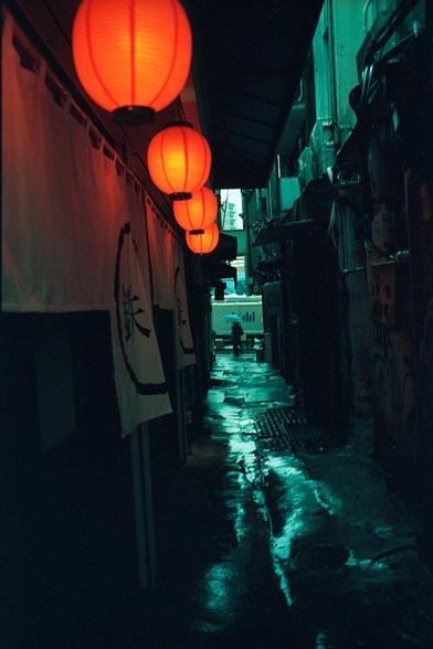 Red lanterns in an alley in Tokyo on a rainy afternoon.