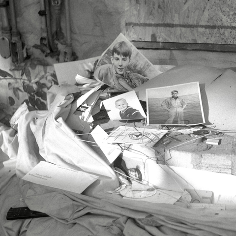 A black and white film photo. Old photos and other personal items cover the outdoor steps of an abandoned house in East Austin, Texas. Wednesday, October 16, 2024. 