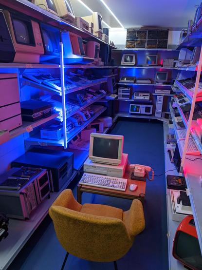 a wooden desk with a classic computer setup, including a CRT monitor, a keyboard, a mouse, and a rotary dial telephone
