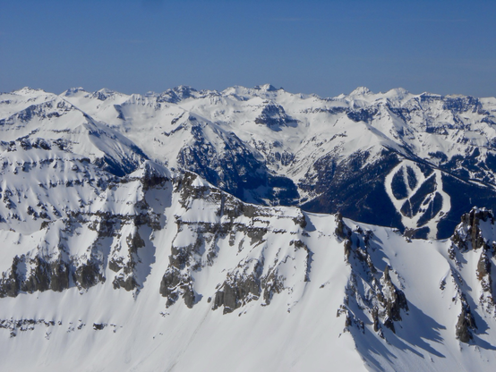 Endless snowy and craggy ridges with ski runs visible 