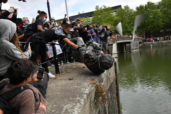 

Masked Protesters throw a statue of slave trader Edward Colston into the harbor during a Black Lives Matter rally on June 7, 2020, in Bristol, England. 
Photograph: Ben Birchall
