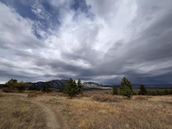 The clouds were being very dramatic over Boulder’s Flatirons today. Rain off to the north, blue skies trying to peek out above me. The golden grass all around the trail. 