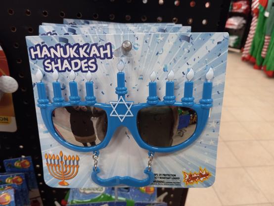 A picture of Hanukkah Shades, tinted glasses with eight 'candles' on top of the glasses area. There is a mustache attached to the bottom of the glasses for unknown reasons.