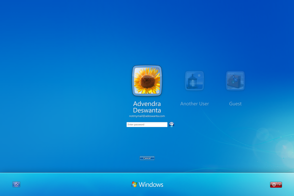 PUoW's Windows 10 login screen, shows 3 users with 1 user in an authentication state and a cancel button to cancel an operation. It also shows a bottom bar with an accessibility button on the left, a shutdown button on the right, and the Windows logo in the center.