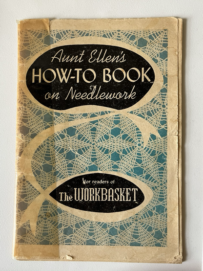 Very old paper booklet, showing signs of wear with cracked edges and yellowing tape. The title is “Aunt Ellen’s How-to Book on Needlework”.