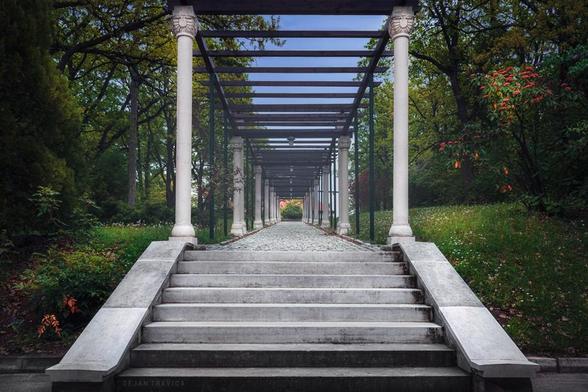 I took this photo once when I visited Oplenac, a hill in Topola, a small town in the heart of Serbia which is known for the famous vineyards of the royal dynasty Karadjordjevic as well as for the church of St. George, so it is one of the most visited tourist attractions in Serbia.

These stairs and a paved path between decorative white granite pillars, and greenery in the beautiful park lead from the King's villa to the villa of Queen Maria on the Oplenac hill near Topola in Serbia. These two villas were built for the needs of the Serbian royal family Karađorđević. The Queen's Villa, the country house or the Queen's Villa is a spacious one-story building surrounded by porches on three sides that are flush with the roof and was built in 1926. In this building, Queen Maria most often stayed with the crown prince Peter and princes Tomislav and Andrej.
Around the villas, there is a forest, which emphasizes its simple beauty even more. The Queen's Villa and the King's Villa are today under the jurisdiction of the Government of the Republic of Serbia, and the family of His Highness the Crown Prince Alexander sometimes stays there.

Topola, central Serbia. From the Parks and Gardens collection. 